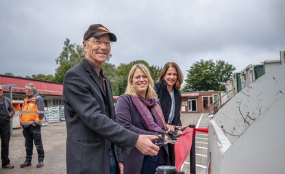 Daniela Enslein, Maike Schaefer und Dr. Christian Vater schneiden das Band an der Modern-Station Kirchhuchting durch. | © Die Bremer Stadtreinigung